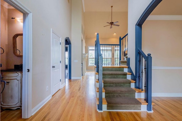2433 San Milano Pl, Lexington, KY 40509 - stairway with arched walkways, ceiling fan, wood finished floors, baseboards, and a towering ceiling