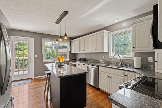 105 Wellington Cv, Danville, KY 40422 - kitchen featuring appliances with stainless steel finishes, a sink, a center island, light wood-type flooring, and a textured ceiling