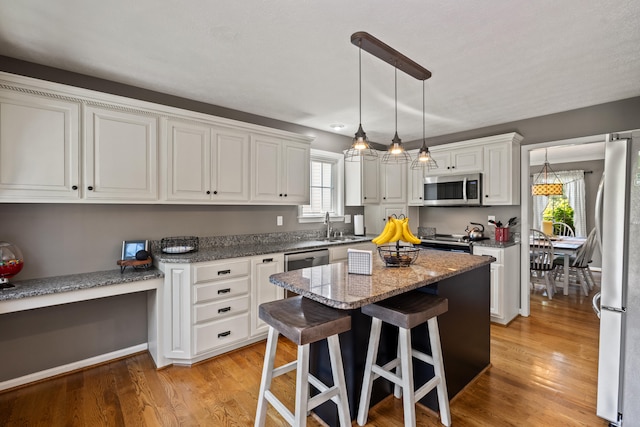 105 Wellington Cv, Danville, KY 40422 - kitchen featuring stainless steel appliances, white cabinets, a kitchen island, and a breakfast bar