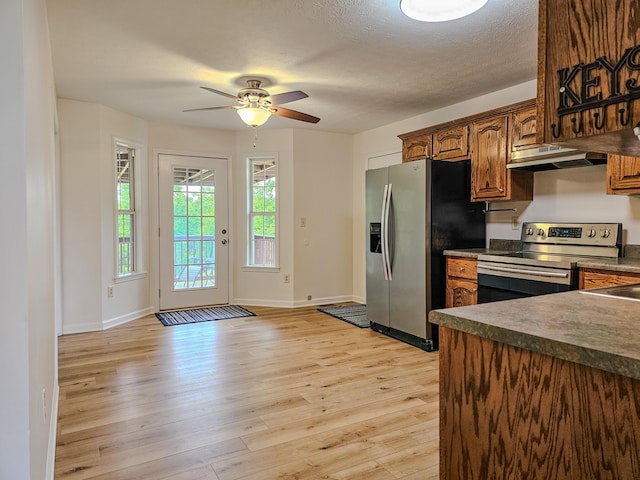 186 Amber Ln, Hustonville, KY 40437 - kitchen with stainless steel appliances, a ceiling fan, dark countertops, light wood-style flooring, and under cabinet range hood