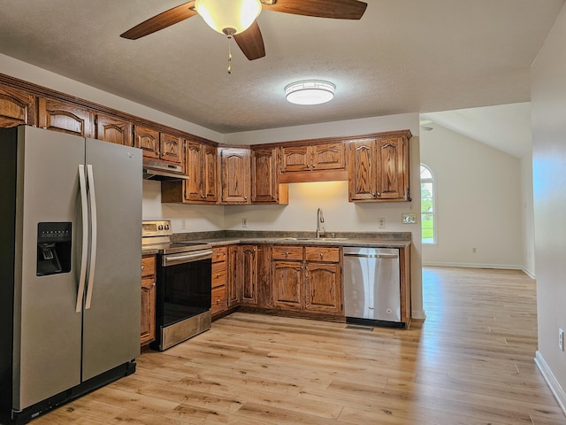 186 Amber Ln, Hustonville, KY 40437 - kitchen with stainless steel appliances, dark countertops, light wood-style flooring, a sink, and a textured ceiling