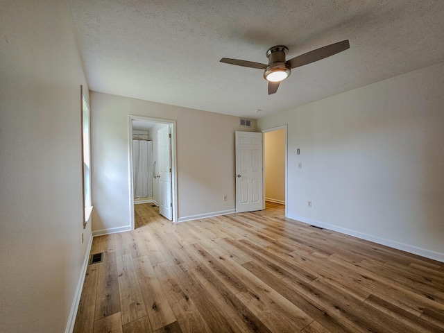 186 Amber Ln, Hustonville, KY 40437 - unfurnished bedroom with light wood-style floors, baseboards, a textured ceiling, ensuite bathroom, and ceiling fan