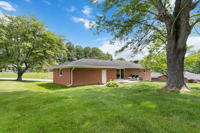 131 Reasor St, Corbin, KY 40701 - rear view of property featuring a patio, brick siding, and a yard