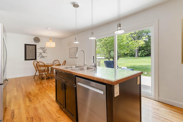131 Reasor St, Corbin, KY 40701 - kitchen with stainless steel appliances, a sink, light wood-type flooring, hanging light fixtures, and dark brown cabinets