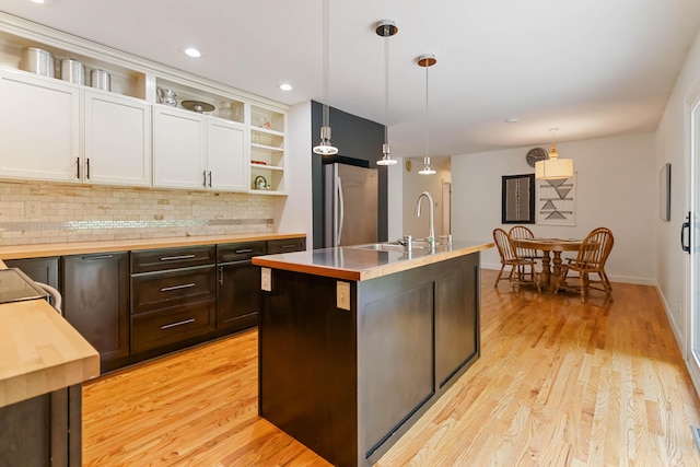 131 Reasor St, Corbin, KY 40701 - kitchen with freestanding refrigerator, open shelves, white cabinetry, butcher block countertops, and decorative backsplash