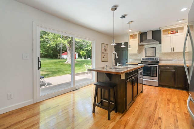 131 Reasor St, Corbin, KY 40701 - kitchen featuring wall chimney exhaust hood, stainless steel appliances, a sink, tasteful backsplash, and a kitchen island with sink