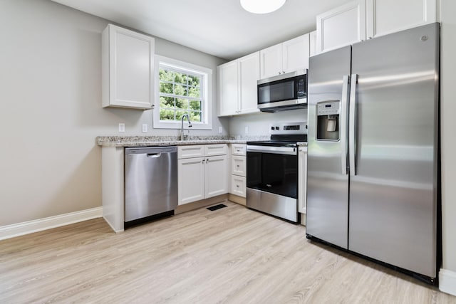 56 Hopewell Church Rd, Corbin, KY 40701 - kitchen with appliances with stainless steel finishes, light wood-style floors, white cabinetry, and light stone counters