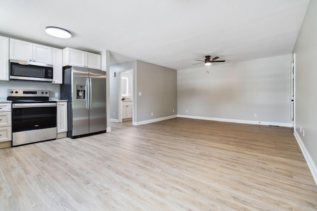 56 Hopewell Church Rd, Corbin, KY 40701 - kitchen featuring stainless steel appliances, ceiling fan, light wood-type flooring, white cabinetry, and baseboards