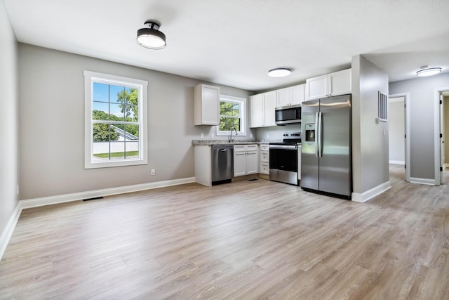 56 Hopewell Church Rd, Corbin, KY 40701 - kitchen with appliances with stainless steel finishes, baseboards, white cabinets, and light wood-style floors