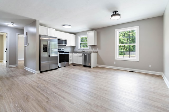 56 Hopewell Church Rd, Corbin, KY 40701 - kitchen with stainless steel appliances, a sink, baseboards, and white cabinetry