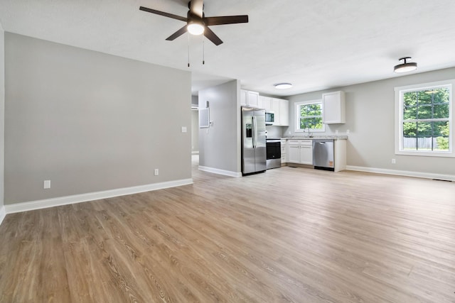 56 Hopewell Church Rd, Corbin, KY 40701 - unfurnished living room with a sink, ceiling fan, light wood-style flooring, and baseboards