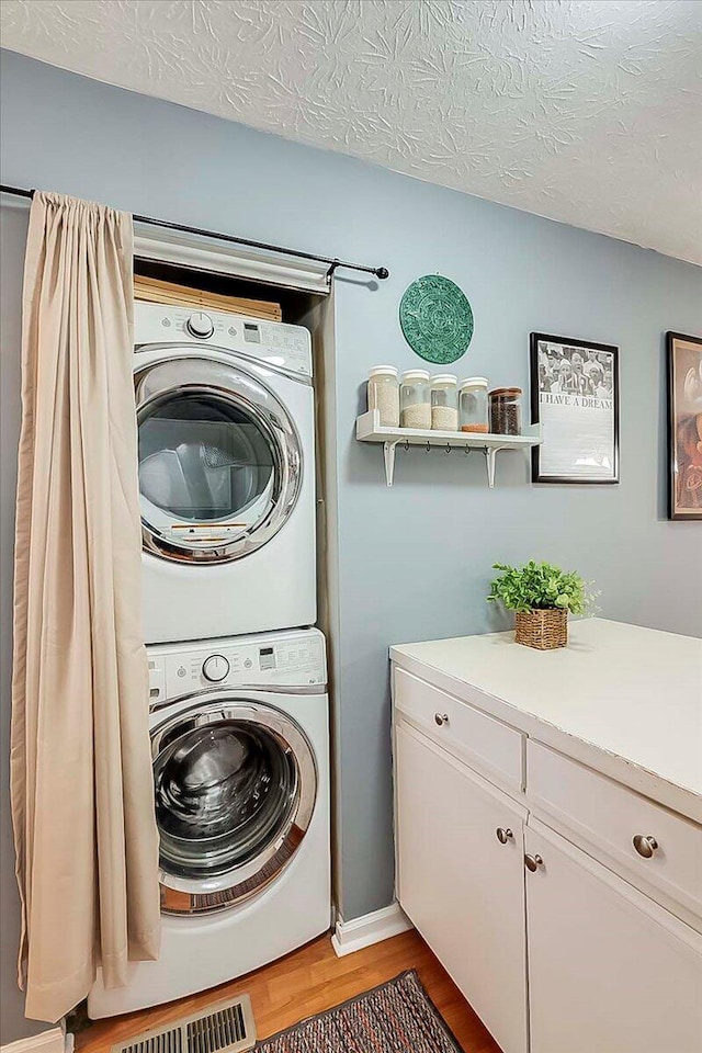 3471 Pimlico Pkwy Unit B, Lexington, KY 40517 - laundry room with stacked washer / drying machine, light wood-style floors, and a textured ceiling
