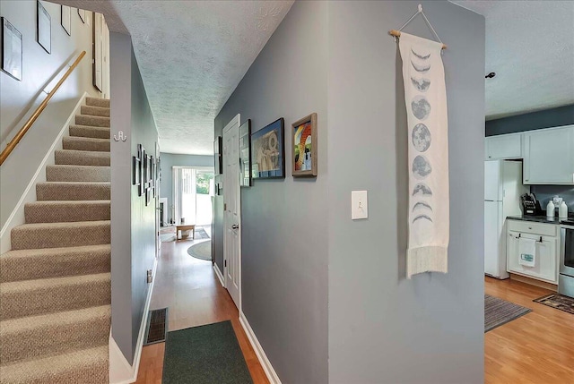 3471 Pimlico Pkwy Unit B, Lexington, KY 40517 - hallway with a textured ceiling, light wood-style flooring, stairs, and baseboards