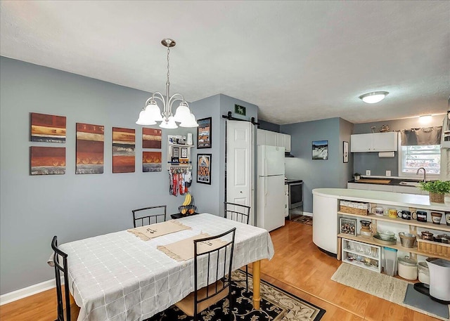 3471 Pimlico Pkwy Unit B, Lexington, KY 40517 - dining area featuring a barn door, a chandelier, light wood finished floors, and baseboards