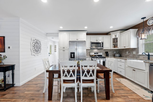795 Allendale Dr, Lexington, KY 40503 - kitchen featuring stainless steel appliances, a sink, wooden walls, tasteful backsplash, and wood finished floors
