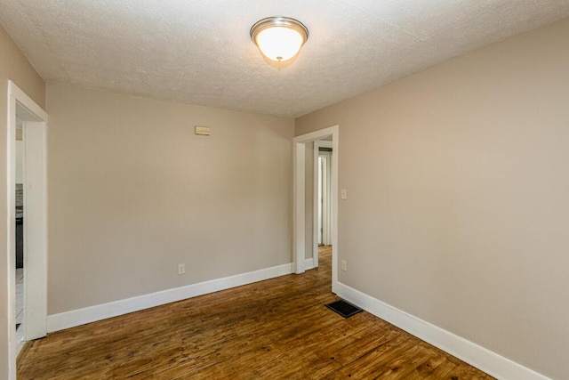 100 Mcdonald St, Nicholasville, KY 40356 - spare room featuring dark wood finished floors, baseboards, and a textured ceiling