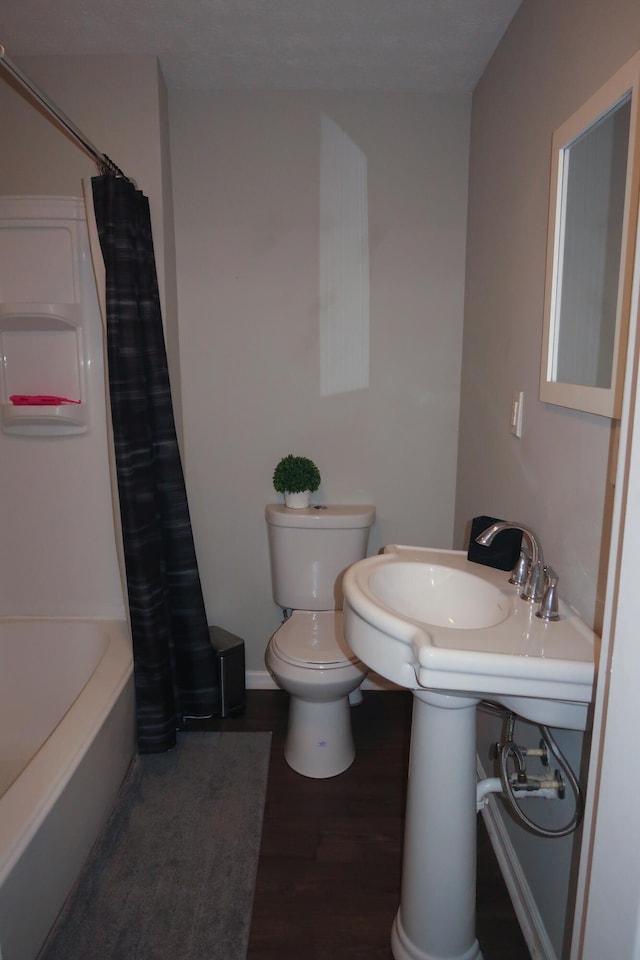 557 Chestnut St, Lexington, KY 40508 - bathroom with toilet, wood finished floors, shower / bathtub combination with curtain, and baseboards