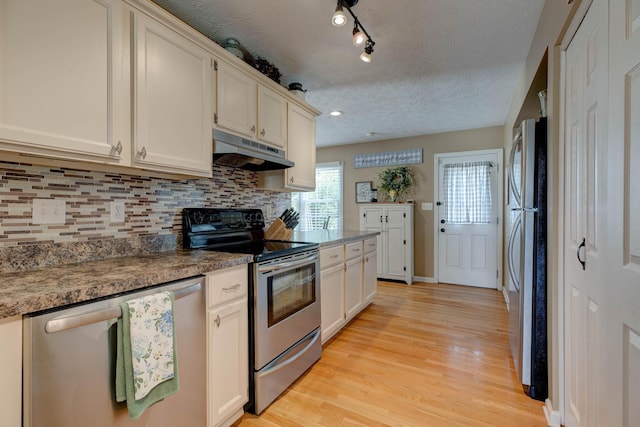 220 Mcdowell Dr, Winchester, KY 40391 - kitchen with stainless steel appliances, under cabinet range hood, light wood-style floors, decorative backsplash, and a textured ceiling