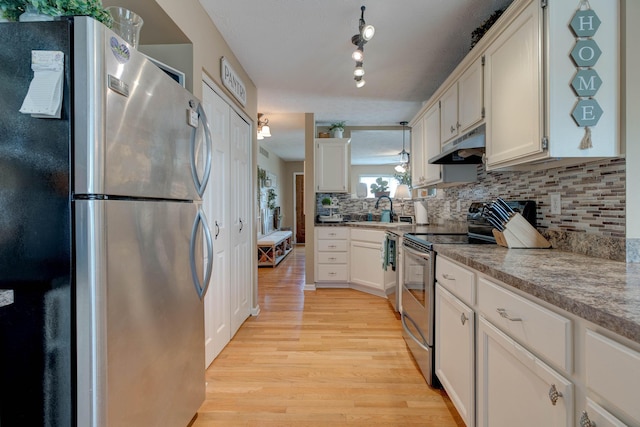 220 Mcdowell Dr, Winchester, KY 40391 - kitchen featuring appliances with stainless steel finishes, under cabinet range hood, light wood-type flooring, backsplash, and white cabinetry