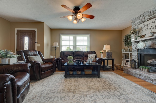 220 Mcdowell Dr, Winchester, KY 40391 - living room featuring a ceiling fan, wood finished floors, a textured ceiling, and a stone fireplace