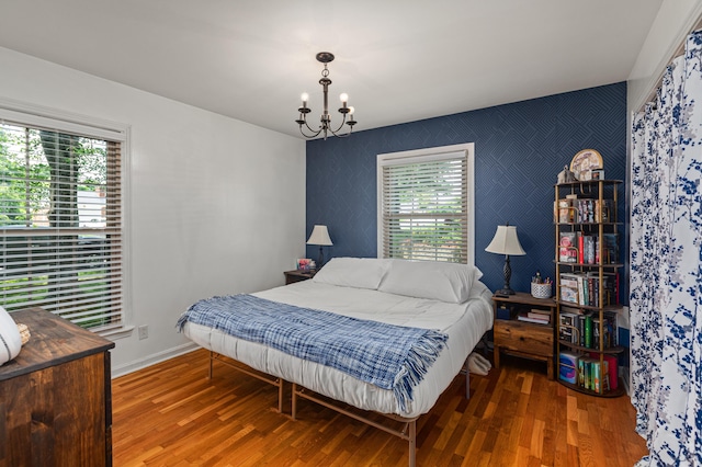 1128 Kiowa Trl, Frankfort, KY 40601 - bedroom featuring an accent wall, a chandelier, and wood finished floors
