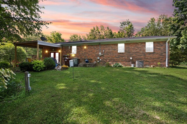 600 Tug Branch Rd, Clay City, KY 40312 - back of property at dusk featuring a yard, brick siding, and central air condition unit
