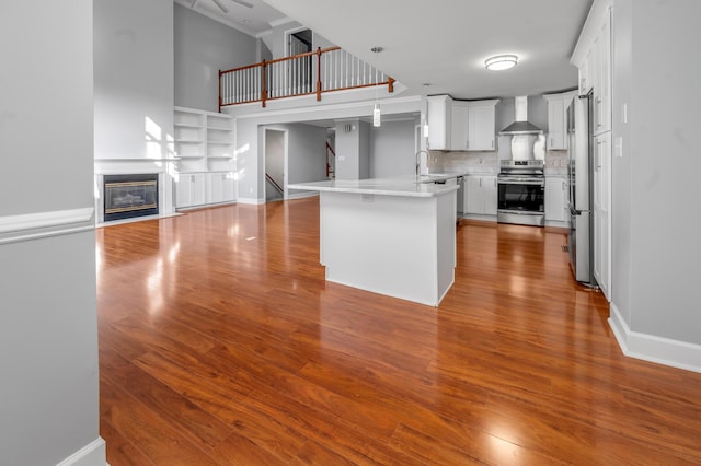 244 Chippendale Cir, Lexington, KY 40517 - kitchen featuring appliances with stainless steel finishes, wall chimney exhaust hood, a peninsula, open floor plan, and wood finished floors