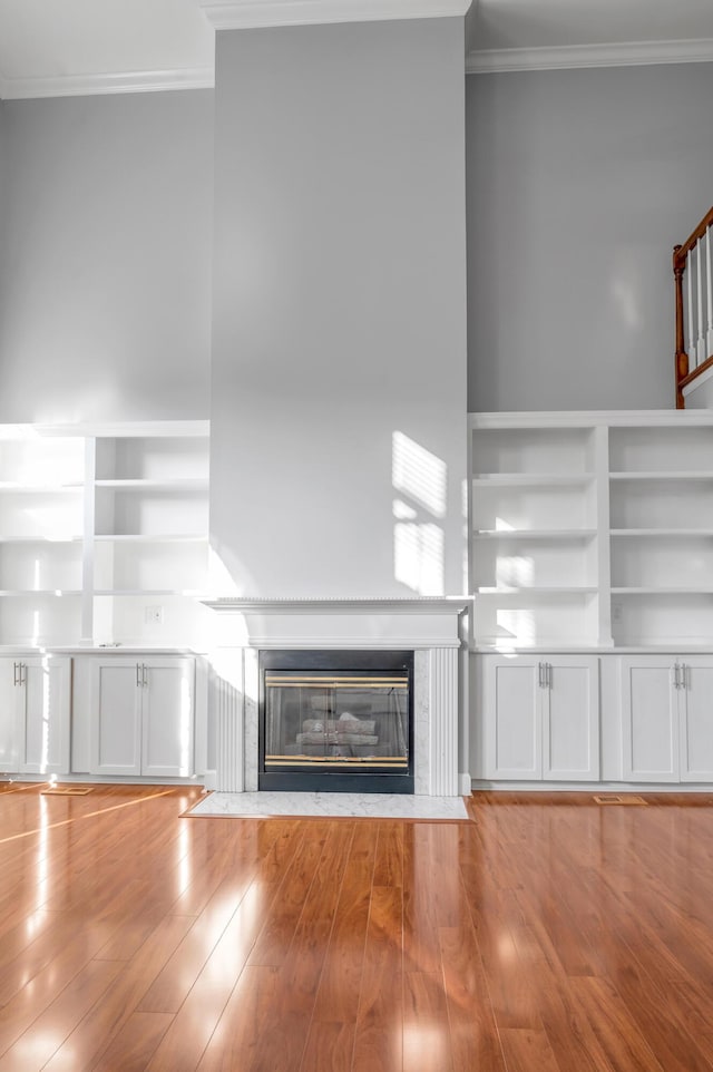 244 Chippendale Cir, Lexington, KY 40517 - unfurnished living room with crown molding, a fireplace with flush hearth, wood finished floors, and stairs