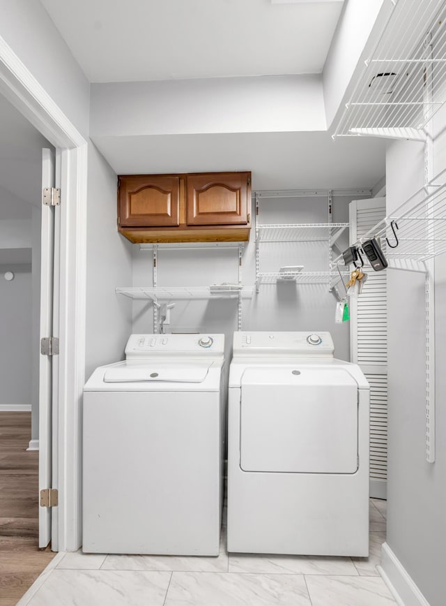 244 Chippendale Cir, Lexington, KY 40517 - washroom featuring separate washer and dryer, cabinet space, light marble finish flooring, and baseboards