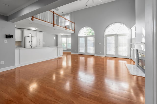 244 Chippendale Cir, Lexington, KY 40517 - unfurnished living room with a fireplace, light wood-type flooring, a towering ceiling, ornamental molding, and baseboards