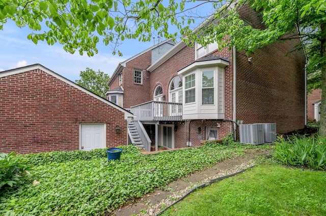 244 Chippendale Cir, Lexington, KY 40517 - back of house with stairs, brick siding, a wooden deck, and central AC