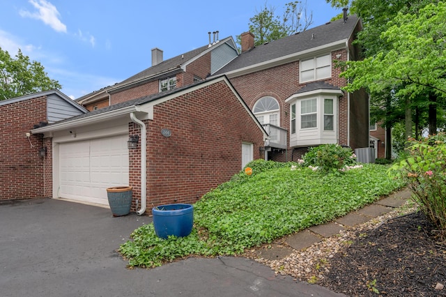 244 Chippendale Cir, Lexington, KY 40517 - view of home's exterior with driveway, a garage, brick siding, and a chimney