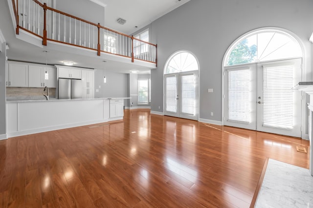 244 Chippendale Cir, Lexington, KY 40517 - unfurnished living room with french doors, light wood-style floors, a towering ceiling, healthy amount of natural light, and crown molding