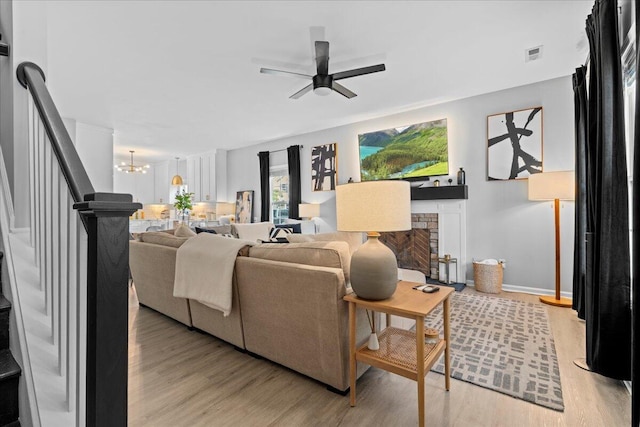 588 E Fifth St, Lexington, KY 40508 - living area with light wood-style floors, a ceiling fan, a fireplace, and stairway