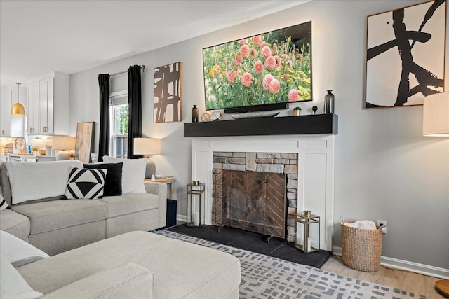 588 E Fifth St, Lexington, KY 40508 - living area featuring a fireplace, baseboards, and wood finished floors