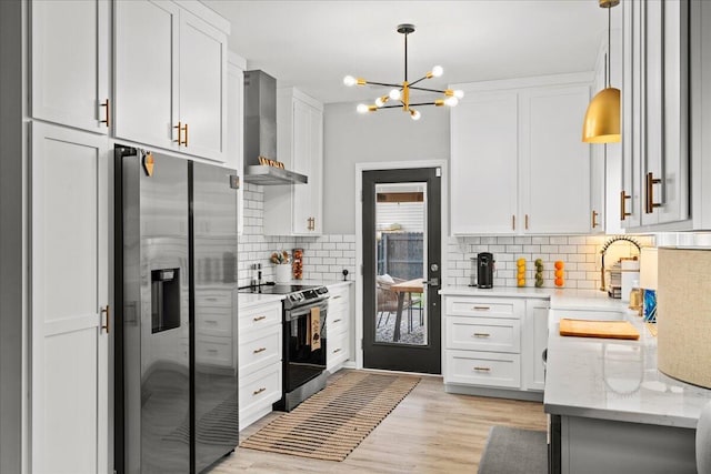 588 E Fifth St, Lexington, KY 40508 - kitchen featuring stainless steel appliances, wall chimney range hood, a sink, a chandelier, and backsplash