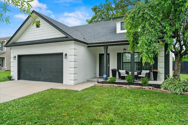 588 E Fifth St, Lexington, KY 40508 - view of front of property featuring a front lawn, outdoor lounge area, an attached garage, covered porch, and concrete driveway