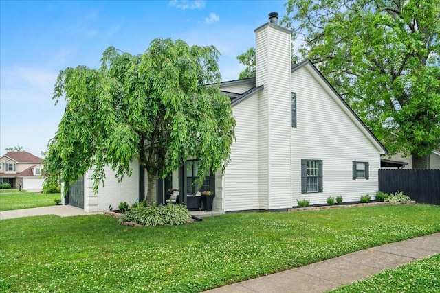588 E Fifth St, Lexington, KY 40508 - view of home's exterior featuring a chimney, an attached garage, and concrete driveway