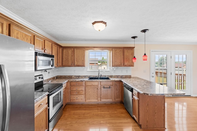 174 Shirdell Dr, Richmond, KY 40475 - kitchen featuring appliances with stainless steel finishes, a sink, a peninsula, brown cabinetry, and light wood-style floors