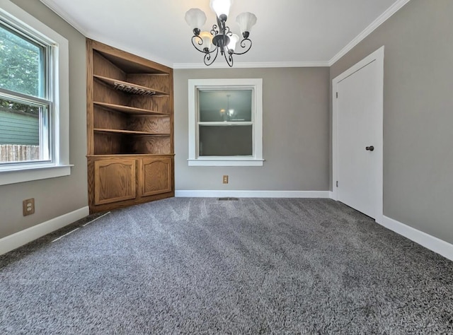 213 W Elm St, Nicholasville, KY 40356 - carpeted spare room featuring a chandelier, crown molding, baseboards, and built in features