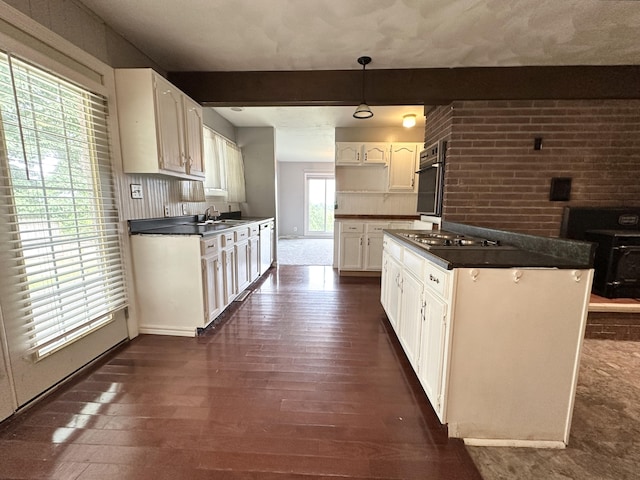 100 Mockingbird Hill Ln, Corbin, KY 40701 - kitchen with dark countertops, black oven, baseboards, stainless steel gas stovetop, and white cabinetry
