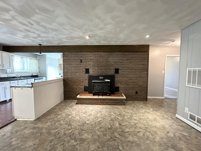 100 Mockingbird Hill Ln, Corbin, KY 40701 - unfurnished living room with a heating unit, a wood stove, and a sink