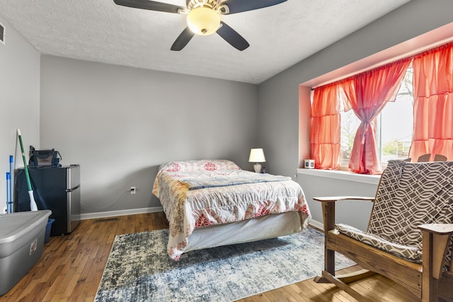 816 Stratton Ln, Winchester, KY 40391 - bedroom with wood-type flooring, baseboards, ceiling fan, freestanding refrigerator, and a textured ceiling