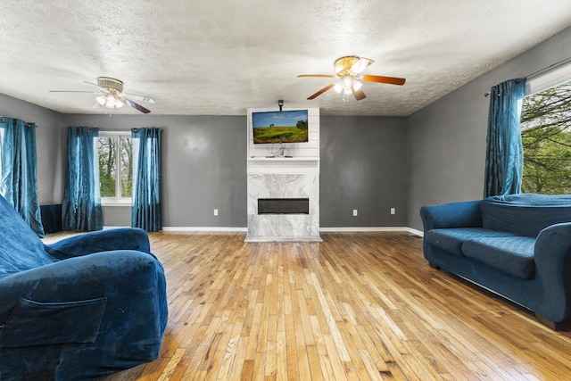 816 Stratton Ln, Winchester, KY 40391 - living room featuring ceiling fan, wood-type flooring, a textured ceiling, a fireplace, and baseboards