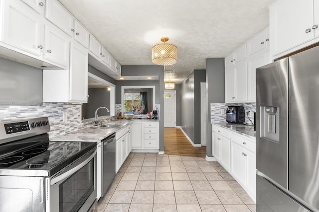 816 Stratton Ln, Winchester, KY 40391 - kitchen with stainless steel appliances, a sink, white cabinets, tasteful backsplash, and a textured ceiling