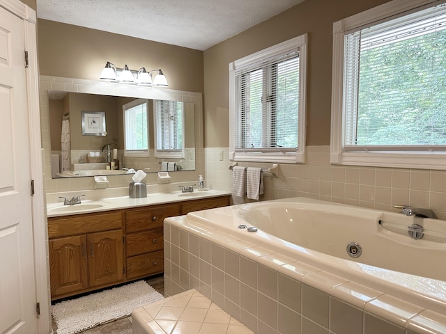 153 Pine Trail Rd, London, KY 40744 - bathroom featuring a jetted tub, plenty of natural light, double vanity, tile patterned floors, and a textured ceiling