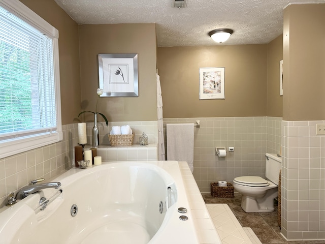 153 Pine Trail Rd, London, KY 40744 - full bathroom with a jetted tub, plenty of natural light, tile walls, tile patterned flooring, and a wainscoted wall