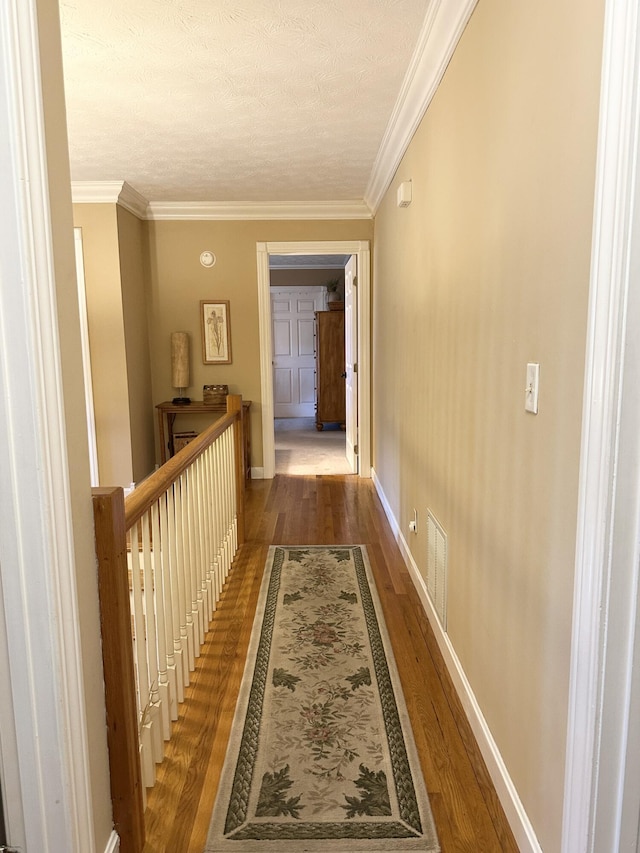 153 Pine Trail Rd, London, KY 40744 - corridor featuring wood finished floors, ornamental molding, an upstairs landing, and a textured ceiling