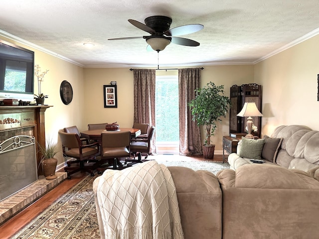 153 Pine Trail Rd, London, KY 40744 - living area with wood finished floors, ceiling fan, a fireplace, a textured ceiling, and ornamental molding