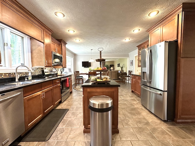 153 Pine Trail Rd, London, KY 40744 - kitchen with appliances with stainless steel finishes, dark countertops, a center island, backsplash, and crown molding